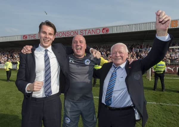 Paul Cook is joined on the pitch by chairman David Sharpe and owner Dave Whelan