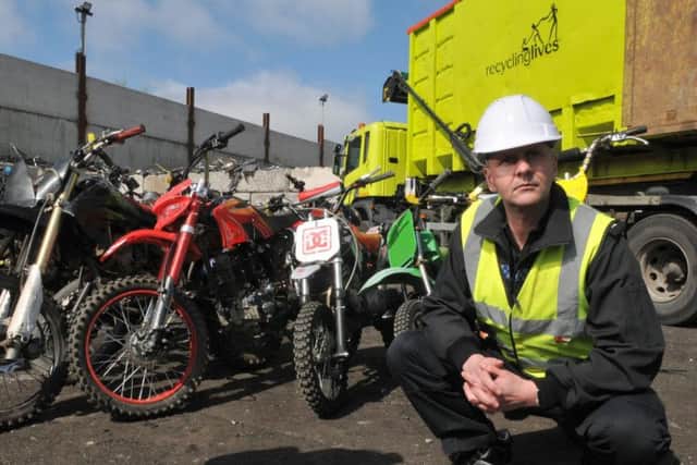 Superintendent Gareth Parkin of Greater Manchester Police with some of the bikes about to be crushed