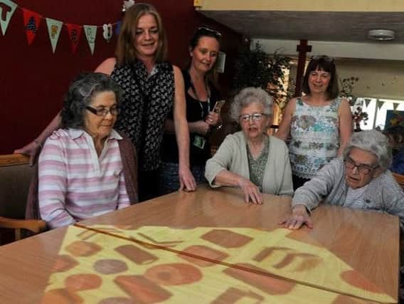 Some of the residents at Cardinal Heenan House care home try out the Tovertafel magic table