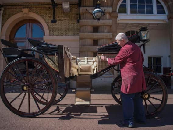 Martin Oates, Senior Carriage Restorer, polishes the Ascot Landau