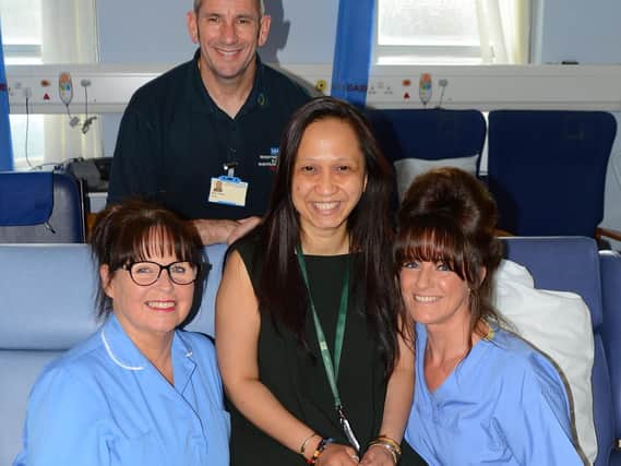 Front left to right: auxiliary Diane Barron, Pensioners Link project
co-ordinator Tutik Ratnasari, auxiliary Jane Connolly and (back) porter John Aspey in the Wigan Infirmary discharge lounge