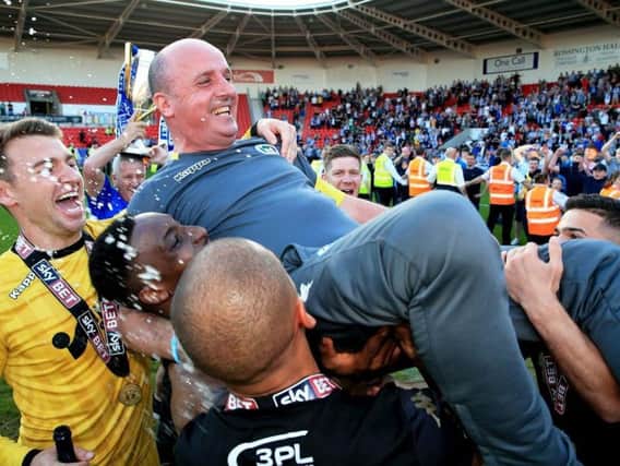 Paul Cook and his squad celebrate winning League One