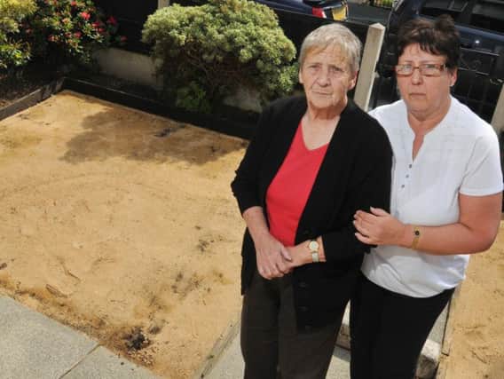 Heartbroken Dorothy Parr, with daughter Carol Unsworth, and the bare patch left after her artificial lawn was stolen overnight